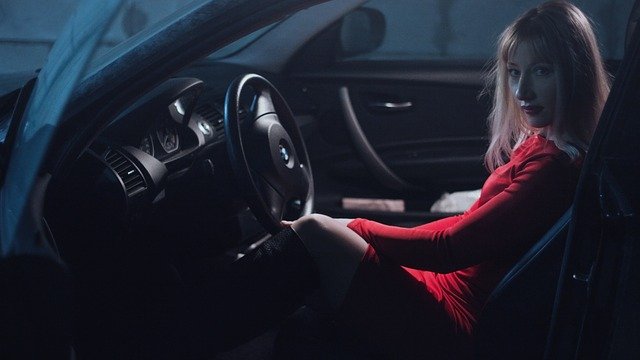dívka v autě v červených šatech
